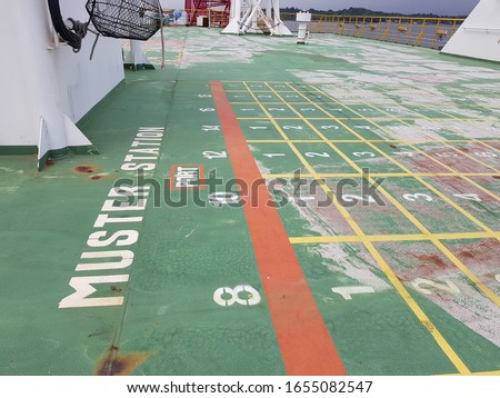 Queue lines at emergency muster station assembly on top deck of a construction work barge 