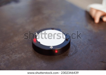 Queue Paging Wireless Calling System on rust steel table background. Communication Technology - Vibrating alert device for receiving food.