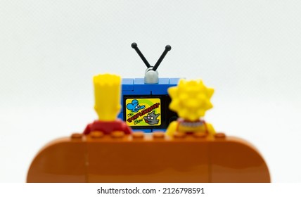 Quezon City, Philippines - February 20, 2022: Lego Simpsons Minifigures Bart and Lisa Simpson watching Itchy and Scratchy on TV while sitting on a couch (wide)