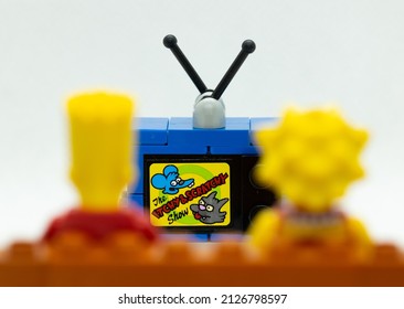 Quezon City, Philippines - February 20, 2022: Lego Simpsons Minifigures Bart and Lisa Simpson watching Itchy and Scratchy on TV while sitting on a couch (close up)