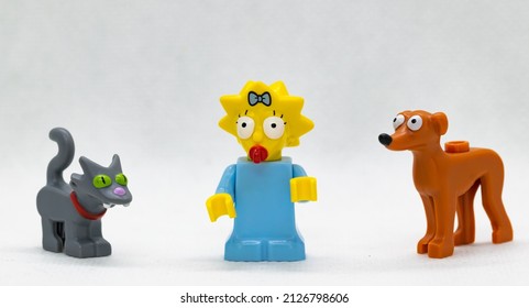 Quezon City, Philippines - February 20, 2022: Lego Simpsons Minifigure Maggie Simpson posed with Lego Cat Snowball and Lego Dog Santa's Little Helper