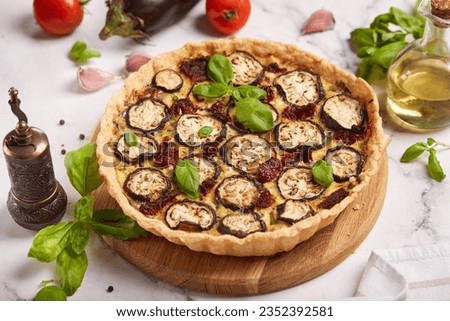 Quiche open tart pie with eggplant, sundried tomatoes and chicken meat. Savory taste