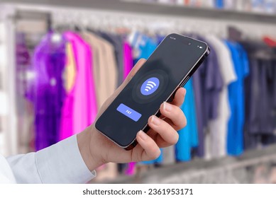 Quick and convenient payment using a mobile phone at a clothing store. Modern phone app interface with NFC payment - Powered by Shutterstock - Get 15% off with code: PIKWIZARD15