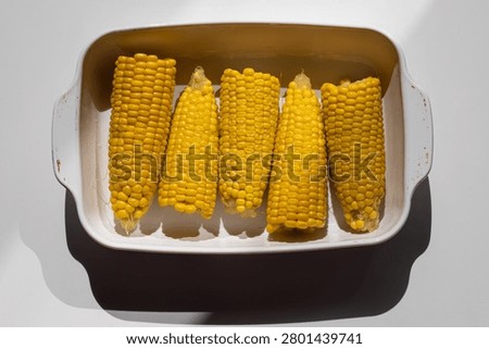 Quick side dish boiled corn in white tray pure white background, side dish complements meat poultry or vegetable mains, side dish ready in minutes with minimal effort. 