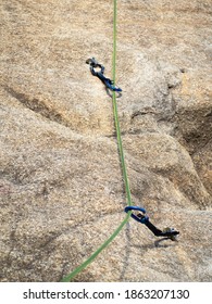 Quickdraws with rope on vertical wall for sport climbing