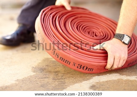 Quickly, get this connected. Cropped image of a firemans hands grabbing a firehose.