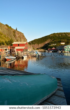 Quidi vidi fishing buildings and dorys, boats reflected in the water with cliffs on both sides in St. John's Newfoundland