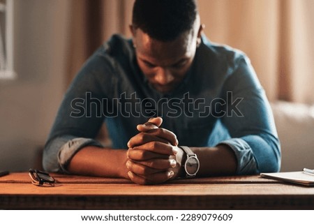 Quiet, calm and spiritual man praying while kneeling with his hands clasped alone at home. Prayerful, spiritual and religious, Christian male saying a daily prayer in the morning in a bedroom