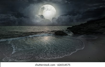 A quiet evening by the ocean with moonlight and a big moon - Powered by Shutterstock