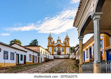 A quiet historic street in the city of Tiradentes in Minas Gerais with colonial houses and a baroque church in the background