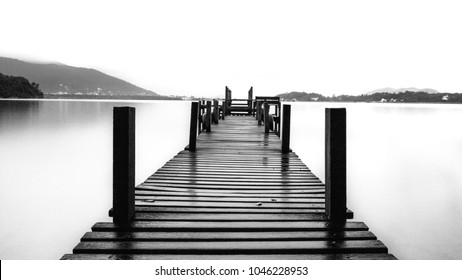 Quiet landscaped gardens with room for text, pier in the calm water sea. - Powered by Shutterstock