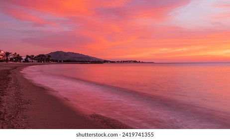 A quiet morning at sunrise in Vera Playa south eastern Spain with a rich red pink sky reflected in the calm seas - Powered by Shutterstock