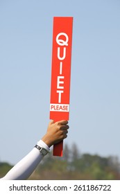 The Quiet Please Sign Was Held Up By Volunteer In Golf Tournament, Before Starting The Game. 