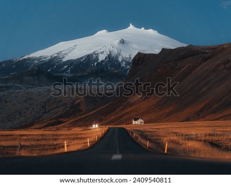 quiet road towards a huge volcanic mountain in the distance, near Snaefellsjokull national park, Iceland.