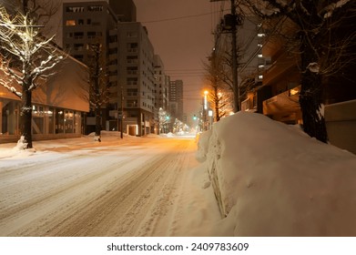 Quiet street at night of Sapporo are covered with thick snow on a winter in  Hokkaido, Japan. - Powered by Shutterstock