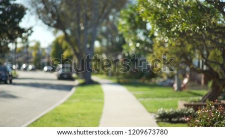 Quiet street scene of the sidewalk and idyllic homes in a suburban neighborhood