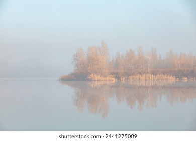 Quiet sunny foggy morning. Fog over the autumn lake at the sunrise moment. - Powered by Shutterstock