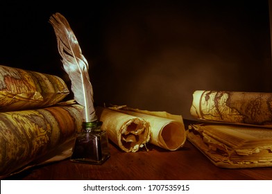 Quill pen, inkwell and old rolled up maps, warm effect