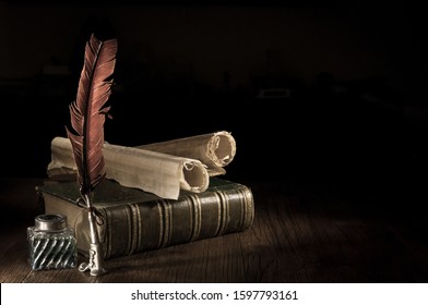Quill pen and a rolled papyrus sheet on a wooden table with old books, vintage effect