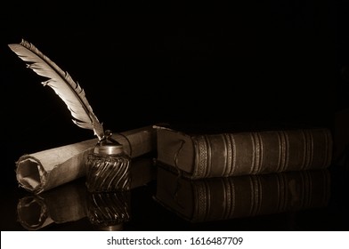 Quill pen and a rolled papyrus sheet on a wooden table with old books, sepia effect
