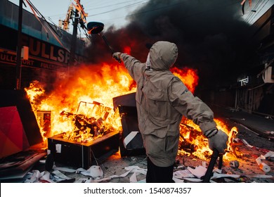 QUILPUE, CHILE - OCTOBER 20, 2019 - Protester throws on fire guard cap looted from a Bank during the protests of the "Evade" movement against the government of Sebastian Pinera