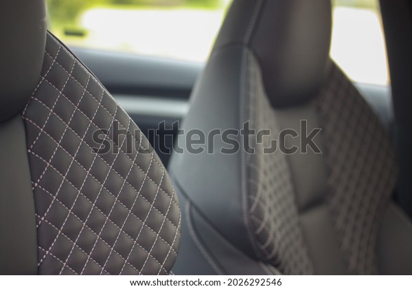 Quilted diamond pattern on the leather seats of a\
sporty vehicle