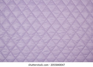 Quilted fabric. The texture of the blanket. Purple textiles	