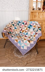 Quilted patchwork quilt on wicker sofa. Vertical