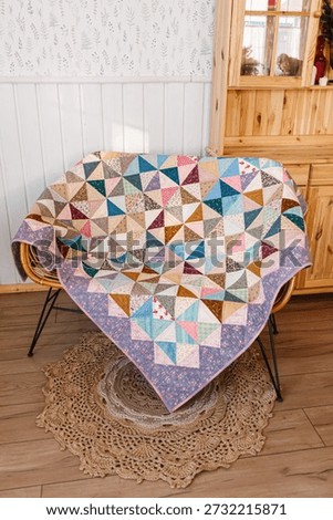 Quilted patchwork quilt on wicker sofa. Vertical