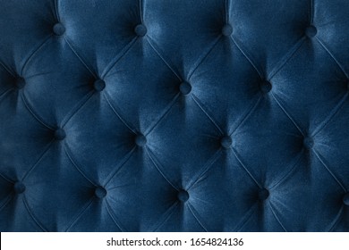 Quilted velour buttoned classic blue color fabric wall pattern background. Elegant vintage luxury sofa upholstery. Interior plush backdrop