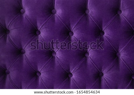 Quilted velour buttoned purple violet color fabric wall pattern background. Elegant vintage luxury sofa upholstery. Interior plush backdrop