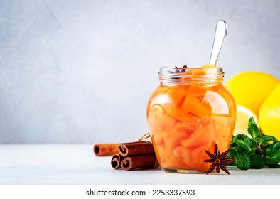 Quince jam or confiture in glass jar with cinnamon and anise on gray kitchen table background, copy space - Shutterstock ID 2253337593