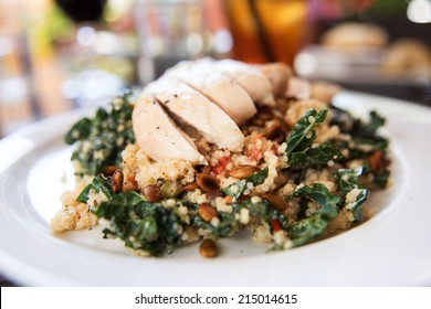 Quinoa And Kale Salad Topped With Sliced Chicken Breast