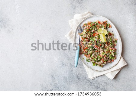 Quinoa Quinua salad with tomatoes and herbs in white bowl.