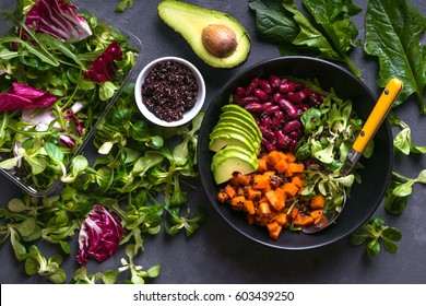 Quinoa salad in bowl with avocado, sweet potato, beans, herbs, spinat on concrete rustic background. Quinoa superfood concept. Clean healthy detox eating. Vegan/vegetarian food. Making healthy salad - Shutterstock ID 603439250