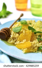 Quinoa salad with grapefruit,orange,mint and honey on a blue plate on light background.