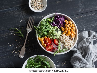 Quinoa and spicy chickpea vegetable vegetarian buddha bowl. Healthy food concept. On a dark background, top view  