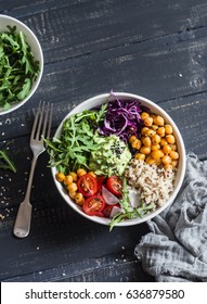 Quinoa and spicy chickpea vegetable vegetarian buddha bowl. Healthy food concept. On a dark background, top view   