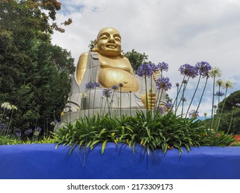 Quinta dos Loridos, Portugal - 06 18 2022: Large golden Buddha in the Bacalhôa Buddha Eden park or Garden of Peace.
