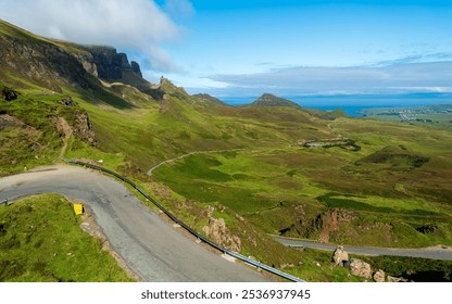 The Quiraing's winding road snakes through vibrant green Highlands landscapes, offering dramatic cliff and ocean views. - Powered by Shutterstock