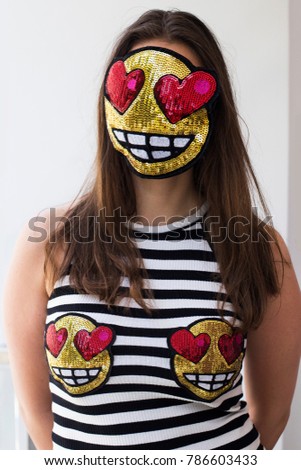 Quirky collage woman wearing stripe dress with love eyes emoji. Funny expressive love emoticon covering her face