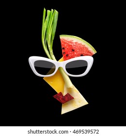 Quirky Food Concept Of Picasso Style Female Face In Sunglasses Made Of Fresh Fruits On Black Background.