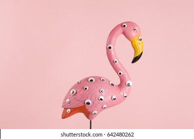 quirky and freak pink plastic flamingo on a pink background with numerous eyesgradient and tones on tones
