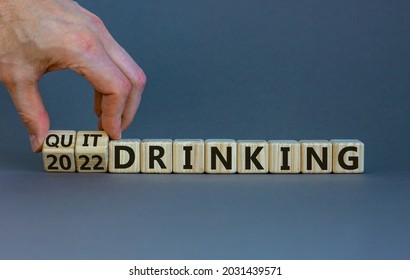 Quit drinking 2022 new years resolution symbol. Businessman turns wooden cubes with words '2022 quit drinking'. Beautiful grey background, copy space. Healthy lifestyle and 2022 quit drinking concept.