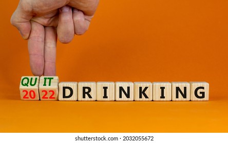 Quit drinking 2022 new years resolution symbol. Businessman turns wooden cubes with words '2022 quit drinking'. Beautiful orange background, copy space. Healthy lifestyle, 2022 quit drinking concept.