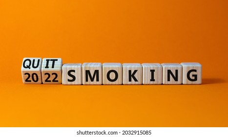 Quit smoking 2022 new years resolution symbol. Turned wooden cubes with words '2022 quit smoking'. Beautiful orange background, copy space. Healthy lifestyle and 2022 quit smoking concept.