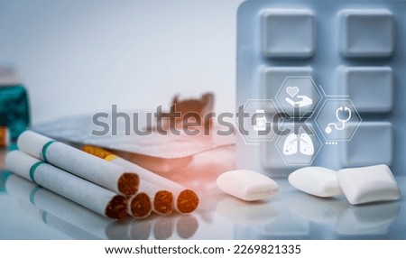 Quit smoking or smoking cessation with nicotine replacement therapy or NRT. 31 May World No Tobacco Day. Nicotine chewing gum in blister pack near pile of cigarettes. Nicotine products to stop smoke.