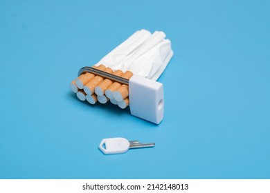 Quit Smoking Concept. Cigarettes Squeezed Into A Lock On A Blue Background. Bad Limiting Habit.