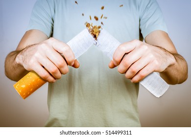 Quit smoking - male smoker breaking giant cigarette
