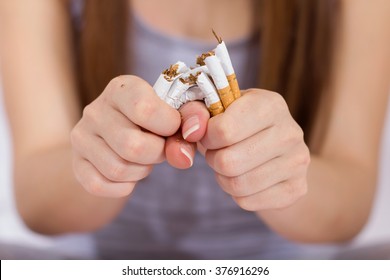 Quit Smoking, woman hands breaking bunch of cigarette.